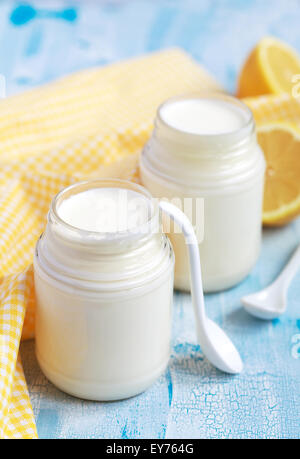 Hausgemachtes Joghurt in zwei kleinen Gläsern auf a blaue Tabelle, selektiven Fokus Stockfoto