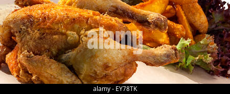 Nahaufnahme des ganzen leckeren Brathähnchen mit Kartoffeln und Salat Stockfoto