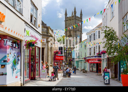 Geschäfte auf Vorderstraße in der Stadt im Zentrum mit Blick auf Holy Trinity Church, St Austell, Cornwall, England, UK Stockfoto