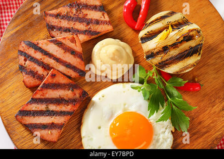 Gegrillter Fleischkäse mit Sonnenseite Spiegelei und Senf Stockfoto