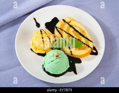 Biskuitrolle Kuchen mit Eis und Schokosauce Stockfoto