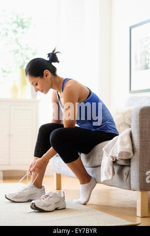 Junge Frau, die Schuhe anziehen Stockfoto