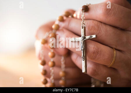 Frau mit Rosenkranz in Händen beten Stockfoto