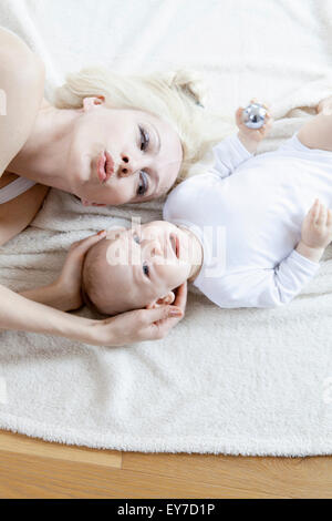 Mutter und Baby liegend auf Decke Stockfoto