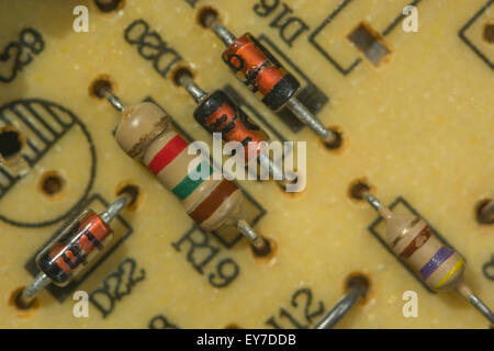 Makrofoto-Kohlewiderstände und -Dioden auf herkömmlicher durchkontaktierten Leiterplatte/Leiterplatte. Elektrischer Widerstand, Nahaufnahme des Schaltkreises. Stockfoto