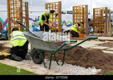 Garten- und Landschaftsarbeiter Ausbildung im Tatton Park, Cheshire, Großbritannien Juli 2015. Letzte Feinheiten auf dem jährlichen RHS Blumenfestival 17th Showground als Lehrlinge in Landschaftsbau und Gartenbau demonstrieren ihre Lehrkünste über drei Tage Herstellung identischer Grundstücke in einem unfertigen kleinen Garten mit Spalier und Pflaster. Stockfoto