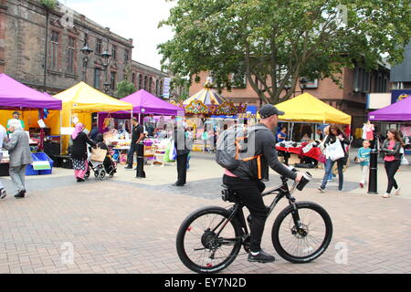 Ein Radfahrer durchläuft Effingham Street im Stadtzentrum von Rotherham am Markttag, Rotherham, South Yorkshire England UK Stockfoto