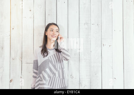 Junge japanische Frau am Telefon in einem stilvollen Büro Stockfoto