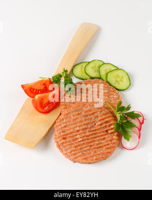 Studioaufnahme von Roh Burger Bratlinge und geschnittenem Gemüse Stockfoto