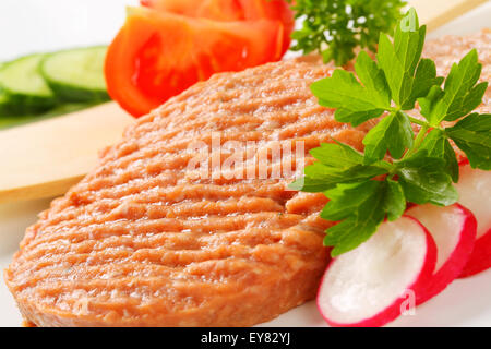 Studioaufnahme von Roh Burger Bratlinge und geschnittenem Gemüse Stockfoto