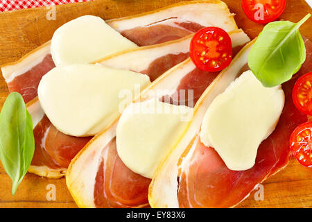 Geschnittenem Prosciutto Crudo und Mozzarella mit frischem Basilikum und Tomaten Stockfoto