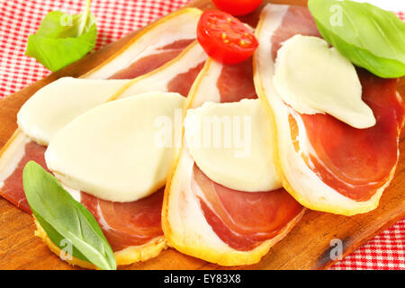 Geschnittenem Prosciutto Crudo und Mozzarella mit frischem Basilikum und Tomaten Stockfoto