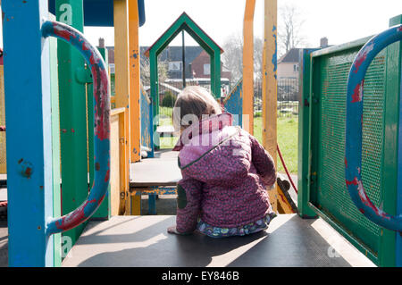 Kleinkind spielt auf einem Klettergerüst im park Stockfoto