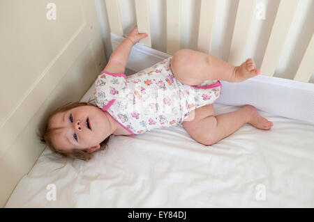 Overhead Schuss von Babymädchen in ihrem Kinderbett liegend Stockfoto