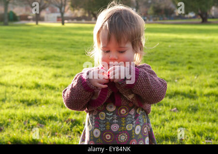 Mädchen versuchen ihre Tasten auf ihrer Strickjacke zu tun, bis Stockfoto