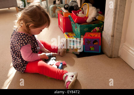 Kleine Mädchen spielen mit Holzspielzeug Stockfoto