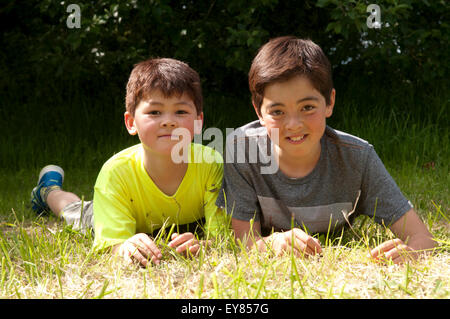 Porträt von zwei Jungs auf dem Rasen lächelnden liegend Stockfoto