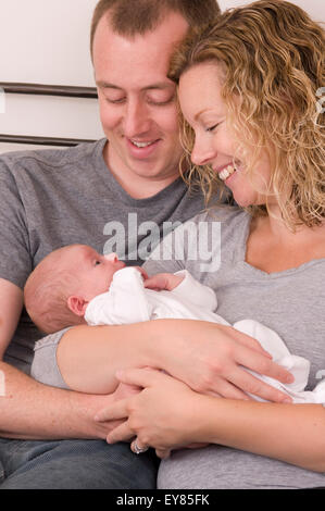 Neue Eltern halten, ihre neugeborenen Babys kuscheln Stockfoto