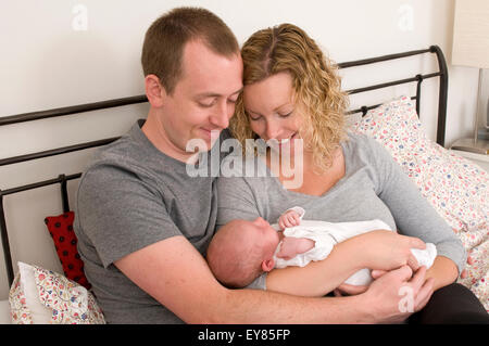 Neue Eltern halten, ihre neugeborenen Babys kuscheln Stockfoto