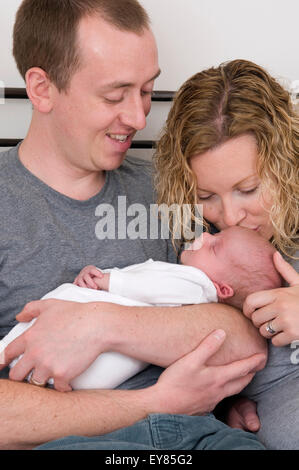 Neue Eltern halten, ihre neugeborenen Babys kuscheln Stockfoto