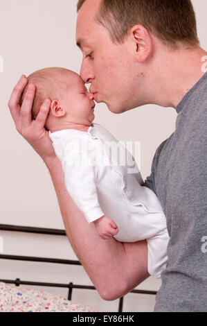 Vater sein neugeborenes Mädchen küssen Stockfoto