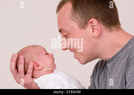 Nahaufnahme eines neugeborenen Mädchens mit einem Kopf in der Hand ihres Vaters Stockfoto