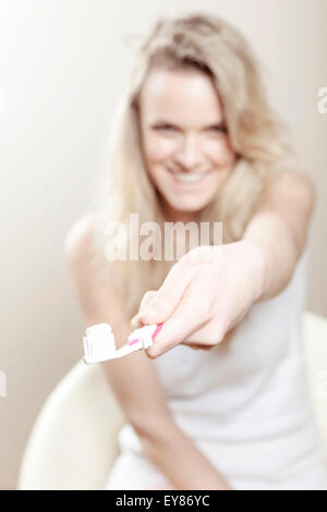 Junge Frau Holding Zahnbürste Stockfoto