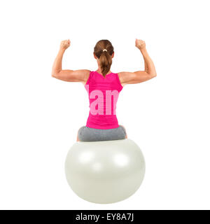 Sportliche Frau auf einem Gymnastik-Ball dabei Training Stockfoto