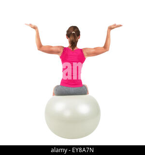 Sportliche Frau auf einem Gymnastik-Ball dabei Training Stockfoto