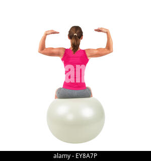 Sportliche Frau auf einem Gymnastik-Ball dabei Training Stockfoto