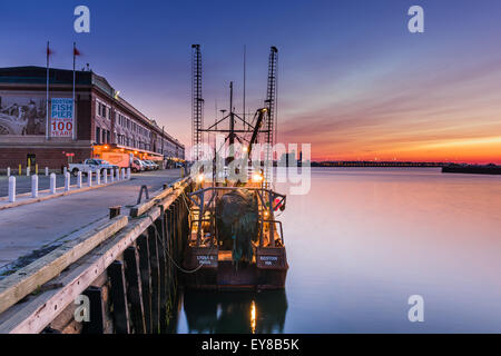 Die Sonne steigt über Logan International Airport, leuchten die Fischerboote vertäut entlang der Fish Pier im Seaport district Stockfoto