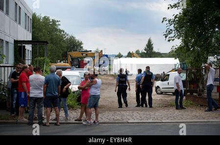 Dresden, Deutschland. 24. Juli 2015. Zuschauer beobachten Sie, wie Polizei Zelte als temporäre Unterkunft für 1.100 Flüchtlinge in Dresden, Deutschland, 24. Juli 2015. Vorhandene Kapazitäten sind nach Angaben der sächsischen Behörden ausgeschöpft. Angesichts der wachsenden Zahl der Flüchtlingsströme in Sachsen sollte die Notunterkünften Obdachlosigkeit unter Asylbewerbern verhindern. Foto: ARNO BURGI/DPA/Alamy Live-Nachrichten Stockfoto