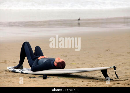 Surfer, die auf einem Brett, die Ruhe am Strand liegen Stockfoto