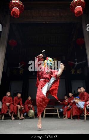 Nanfeng, Chinas Jiangxi Provinz. 23. Juli 2015. Wu Yajun, ein zehn-jährige Junge spielt "Thunder God" Nuo Tanzausbildung in Shiyou Dorf, Sanxi Township Nanfeng Grafschaft, Osten Chinas Jiangxi Provinz, 23. Juli 2015. Nuo Tanz früher Opferrituale im alten China, böse Geister zu vertreiben und beten für gute Ernten. Über ein Jahrzehnt eingerichtet Ye Genming, ein Erbe der Nuo Tanz, eine Teenager-Schulung in Shiyou Dorf Nuo Tanz fort, das angeblich als "lebendes Fossil der alten chinesischen Tanz". © Chen Zixia/Xinhua/Alamy Live-Nachrichten Stockfoto