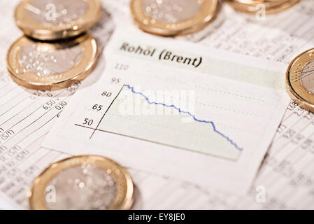 Graph mit einer fallenden Kurve umgeben von Münzen Stockfoto