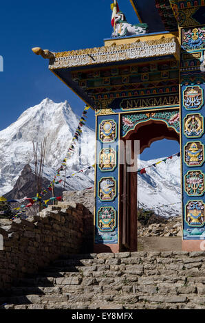 Eingang zum buddhistischen Tempel mit dem Blick auf Mt. Manaslu vom Dorf Lho in das Nubri-Tal in Nepal Stockfoto