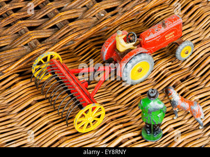 Dinky Spielzeug-Traktor mit Heu Rechen auf Weidenkorb. Stockfoto