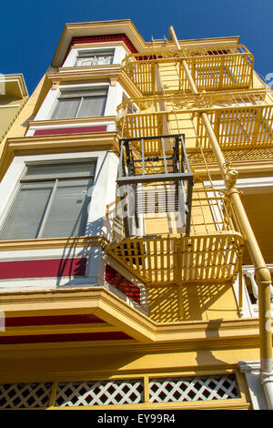 Gelb gestrichenes Haus mit einer eisernen Feuerflucht an der Außenseite des Gebäudes im Telegraph Hill-Viertel von San Francisco, Kalifornien Stockfoto