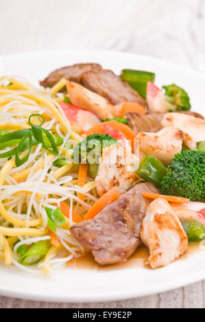 Nudeln mit Huhn, Rind und Crab Stick über helle Oberfläche Stockfoto