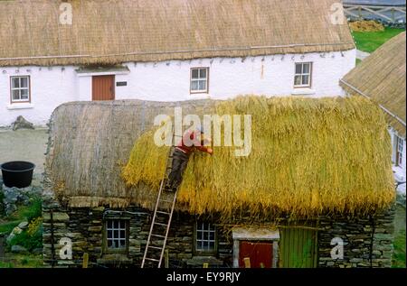 High Angle View eines Mannes Thatching Dach, Folk Village, Glencolmcille, Republik Irland Stockfoto