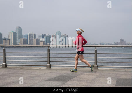 Frau, laufen, Joggen im Hudson River Park.  Manhattan, Jersey City im Hintergrund. NEW YORK CITY. USA. Stockfoto