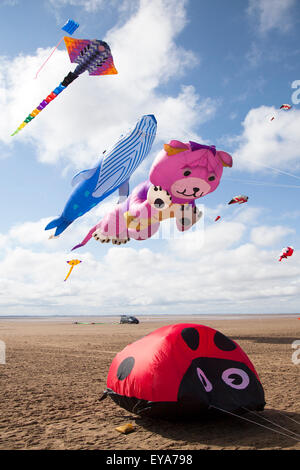 Lytham, Lancashire, UK Marienkäfer, Hund und Teddybär & Boden Bouncer, die an der St Annes Drachenfest am 25. Juli 2015. Der Himmel über der Küste überschwemmt mit Farbe als fabelhafte große Anzeige der riesigen Drachen in die Luft am Strand neben der Seebrücke. Das Festival zum Angebot Single Line Kites in allen Formen und Größen. Stockfoto