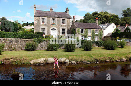 Mädchen, die Polsterung im Fluss Kilbroney, Rostrevor, County Down, Irland Stockfoto