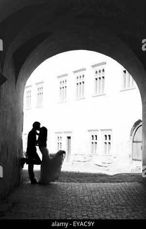 Brautpaar küssen in einem Gang. Schwarz / weiß Bild mit Getreide als Effekt hinzugefügt. Stockfoto