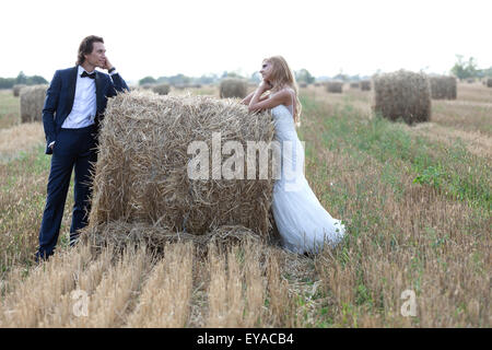 Ehepaar starrte einander tief in der Liebe, auf einen Heuballen. Stockfoto