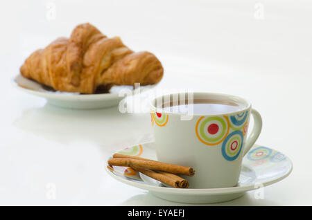 Tee in weiße Tasse mit Zimt und Croissant isoliert auf weißem Hintergrund Stockfoto