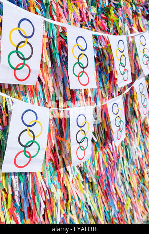 SALVADOR, Brasilien - 11. März 2015: Olympische Flagge Bunting hängt vor dem Hintergrund des guten Glücks brasilianische wünschen Bänder. Stockfoto