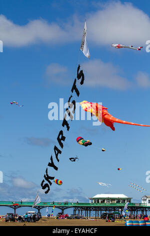 Sky Künstler, die an der St Annes Pier Kite Festival, Lytham-St - Annes, Lancashire, Großbritannien am 25. Juli 2015. Der Himmel über der Küste überschwemmt mit Farbe als fabelhafte Anzeige Drachen in die Luft am Strand neben der Seebrücke. Das festival Single Line empfohlene, Dual, Quad und Power Kites, Windsack, weich, Schlauchboote, Banner, und Lenkdrachen in allen Formen und Größen mit einer Vielzahl von Kitesurf Stoffen Stockfoto