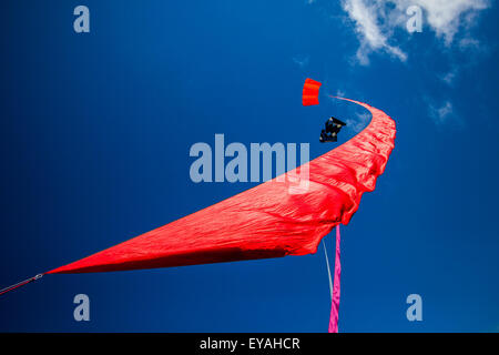 Bunte, geschwungene fliegende Dampfer Drachen segeln in den Himmel in Lytham, Lancashire, UK Kites Trailing Material beim St Annes Kite Festival am 25th. Und 26th. Juli 2015. Der Himmel über der Strandpromenade ist bunt, denn am Strand neben dem Pier werden riesige Drachen in die Luft gejagt. Das Festival zeigte Single Line, Dual Line, Quad Line und Power Kites, Windsock, weich, aufblasbare, Banner, Und Stunt-Drachen in allen Formen und Größen mit einer Vielzahl von Kitesurf-Stoffen Stockfoto