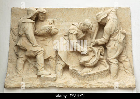 Karpfen angeln. Gips Relief von Tschechischen Bildhauer Karel Hladík (1951) auf die Anzeige in der Südböhmische Galerie (Alšova jihočeská Galerie) in Hluboka Nad Vltavou, Südböhmen, Tschechien. Das Relief in der sozialistischen realistischen Stil zeigt traditionelle Karpfen angeln in der südböhmischen Region. Stockfoto